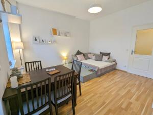 a living room with a bed and a dining room table at Helles Geräumiges Appartement - 10 Min zur Neustadt - Kostenloses Parken - Dresden365 in Dresden
