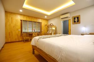a bedroom with a bed and a table with a chair at Mata villa มาตา วิลล่า in Chiang Mai