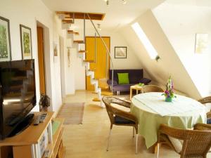 ein Wohnzimmer mit einem Tisch, Stühlen und einer Treppe in der Unterkunft Winzerhof Bitzenhofer in Vogtsburg