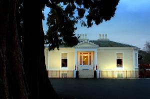 a white house with a porch and a tree at Rocpool Reserve in Inverness
