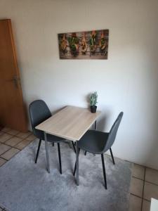 マールにあるMonteurwohnung in Marl - Lipper 70 - 2OGLの木製テーブルと椅子2脚 +1枚の写真