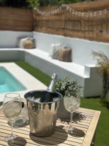a bottle of wine in a bucket on a table with two glasses at Suite lima - benamahoma in Benamahoma
