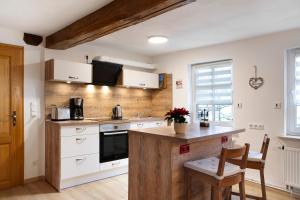 una cucina con mobili bianchi e un piano di lavoro in legno di Ferienwohnung Fachwerk 44 a Frielendorf Altre 22 foto