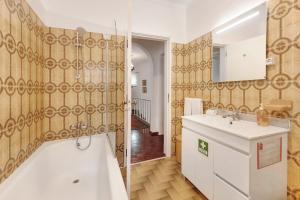 ein Badezimmer mit Badewanne, Waschbecken und Dusche in der Unterkunft Elegant Vintage House with barbecue in Cascais + 20 Fotos