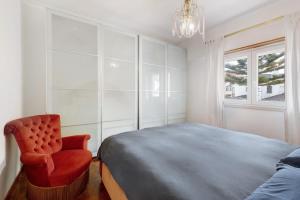 ein Schlafzimmer mit einem Bett, einem Stuhl und einem Kronleuchter in der Unterkunft Elegant Vintage House with barbecue in Cascais