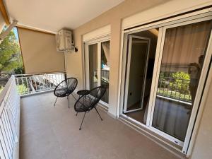 twee stoelen op het balkon van een huis bij Resort Beach Living in Lagonisi in Kalívia Thorikoú