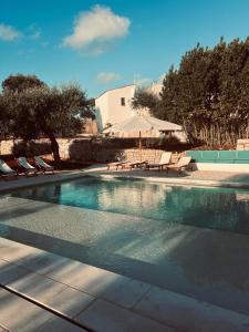 a swimming pool with chaises and chairs in a resort at Masseria Ramasian in Monopoli