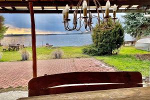 un banco bajo un pabellón con vistas al lago en Dom Nad Brzegiem Jeziora, en Ryn