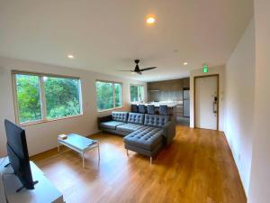 ein Wohnzimmer mit Sofa und Fernseher in der Unterkunft Mopow Niseko in Niseko