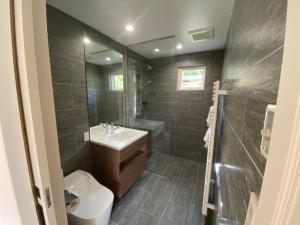 ein Badezimmer mit Waschbecken, Toilette und Dusche in der Unterkunft Mopow Niseko in Niseko