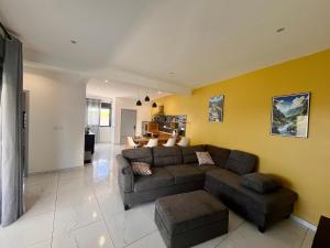 a living room with a brown couch and a yellow wall at Villa Charpentier in Sainte-Marie