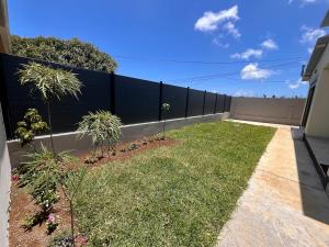 a fence with some plants in a yard at Villa Charpentier in Sainte-Marie +2 photos