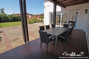 a wooden table and chairs on a patio at 12 Ferienwohnung Familienzeit in Burg auf Fehmarn