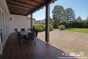 porche con mesa y sillas en el patio en 12 Ferienwohnung Familienzeit, en Burg auf Fehmarn