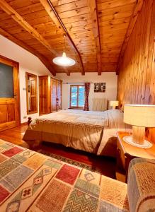 ein Schlafzimmer mit einem großen Bett in einem Zimmer mit Holzdecken in der Unterkunft B&B La Mandorla in Quart