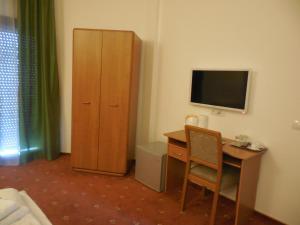 a room with a desk and a television and a cabinet at Villa AnnaLia - Rooms to Rent in Bacău +16 photos