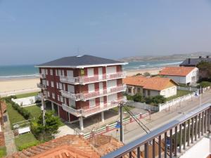 ein Gebäude neben einem Strand mit dem Meer in der Unterkunft Vivero Playa in Suances