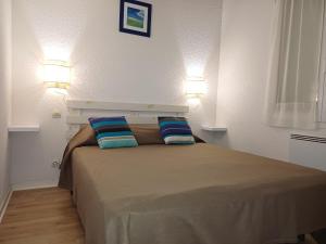 un dormitorio con una cama con dos almohadas. en Maison Indigo 4 personnes, en Biscarrosse-Plage