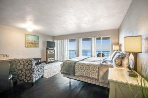 a bedroom with a bed and a desk and windows at Pacific Crest #310 in Newport