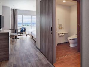 a hotel room with a bed and a bathroom at Grand Mercure Okinawa Cape Zanpa Resort in Yomitan