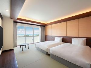 a hotel room with two beds and a large window at Grand Mercure Okinawa Cape Zanpa Resort in Yomitan