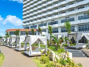 a row of white chairs in front of a building at Grand Mercure Okinawa Cape Zanpa Resort in Yomitan
