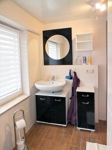 a bathroom with a sink and a mirror at Ferienwohnung Müller in Hohnstein