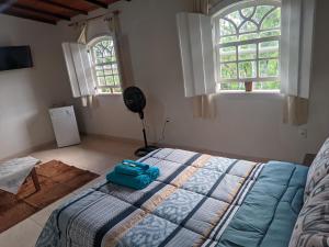 a bedroom with a bed with a blue bag on it at Casa encanto das Gerais in Tiradentes