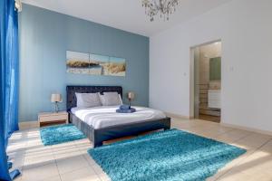 a bedroom with a bed with blue walls and blue rugs at Modern 2BR Sliema Apartment in Sliema