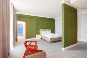 a bedroom with green walls and a bed and a chair at GRAND OPERA HOTEL in Almaty +102 photos