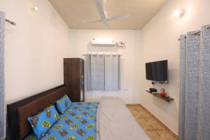 a bedroom with a bed and a flat screen tv at Aditya Cottage in Rishīkesh