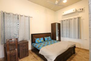 a bedroom with a bed and a ceiling fan at Aditya Cottage in Rishīkesh