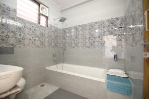 a bathroom with a tub and a toilet and a sink at Aditya Cottage in Rishīkesh +63 photos