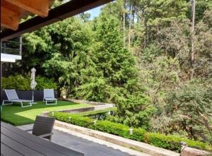a garden with two chairs and a bench and trees at River Home in Valle de Bravo +8 photos