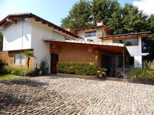 a house with a brick driveway in front of it at River Home in Valle de Bravo