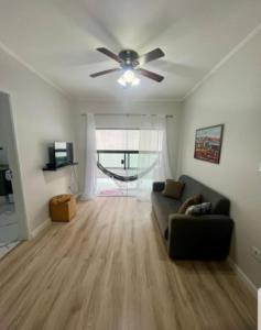 a living room with a couch and a ceiling fan at Apto pé na areia in Mongaguá