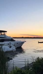 a boat is docked in the water at sunset at Cozy private backyard garden studio in Pickering +25 photos