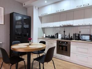 a kitchen with a wooden table and chairs at PB EasyStay in Szczytno