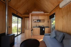 a living room with a blue couch in a tiny house at Refugios Pura vida in La Paloma