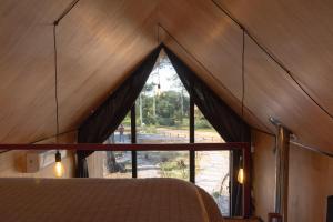 a room with a bed and a large window at Refugios Pura vida in La Paloma