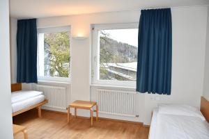 una camera da letto con un letto e una finestra con tende blu di Bildungshaus Arbogast a Götzis