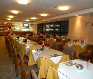 a dining room with tables and chairs with yellow table cloth at HOTEL TAMBAÚ FLAT EXCLUSIVE apt particular in João Pessoa