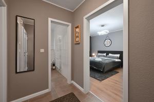 1 dormitorio con cama y pasillo con espejo en SANO - Bei Holger in Hagen - Ruhige Lage - Stylisch - Waschmaschine - Platz zum Arbeiten, en Hagen