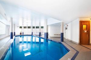 a large swimming pool with blue water in a building at 5mins Walk to Central 2 Bedroom Parking Pool in Sydney