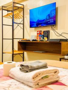 Habitación con cama, TV y toallas. en Avida Riala Staycation in IT Park, Cebu - ITScape, en Cebú