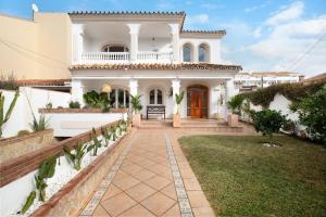 a white house with a pathway leading to the front door at La casita del mar in Torremolinos