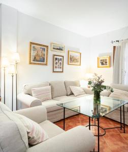 a living room with a couch and a glass table at Casa rural Buenos Días con chimenea, calefacción y barbacoa in Padul