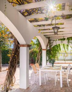 a patio with a white table and chairs at Casa rural Buenos Días con chimenea, calefacción y barbacoa in Padul