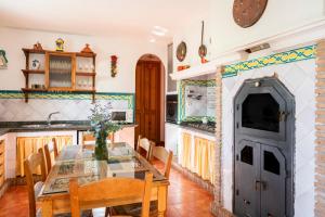 a dining room with a table and a kitchen at Casa rural Buenos Días con chimenea, calefacción y barbacoa in Padul