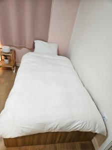 een groot wit bed in een kleine kamer bij Hongdae ssuny house in Seoul